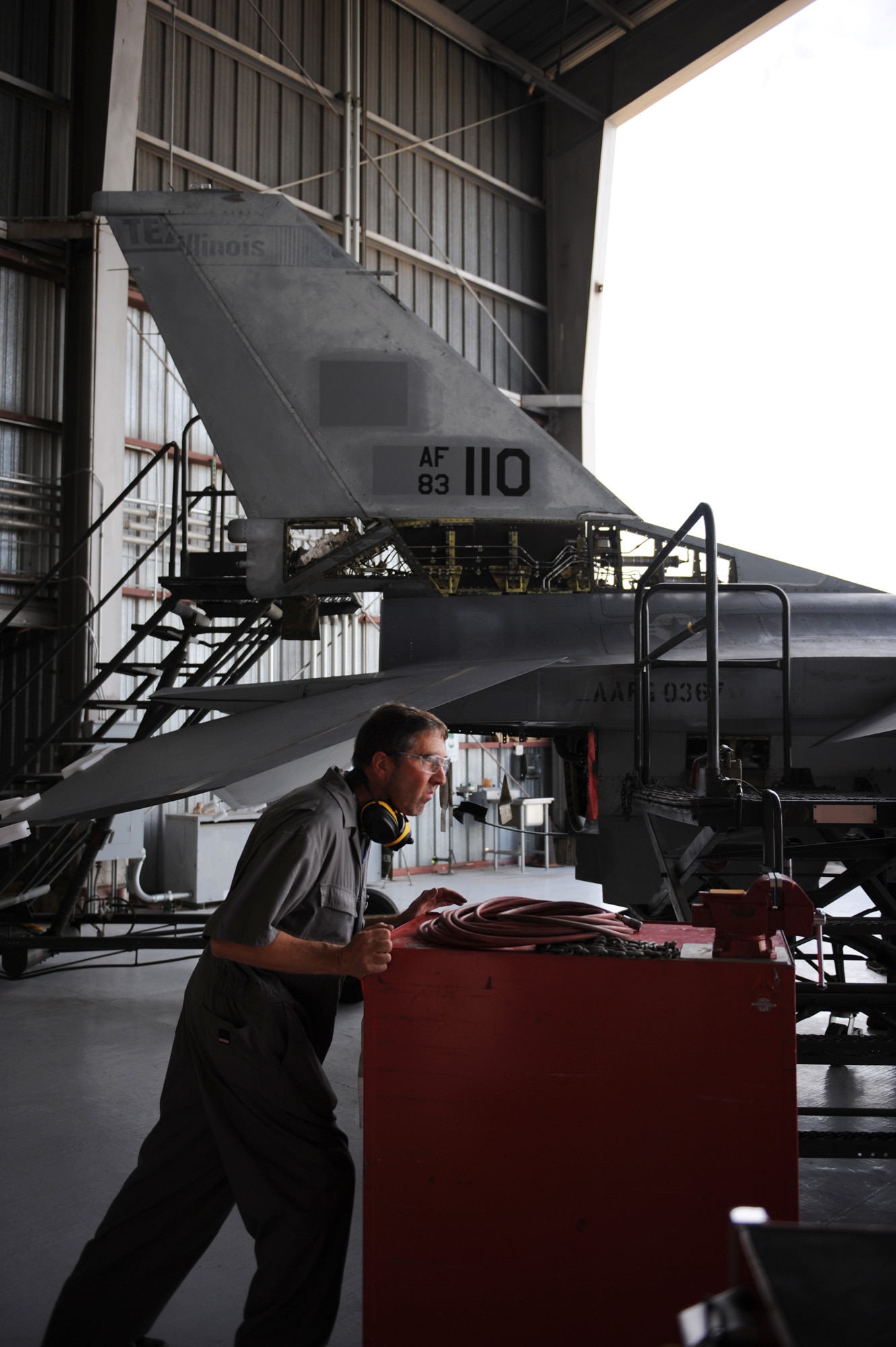 Garth Chitty pushes a toolbox to work on an F-16 Fighting Falcon July 30, 2010, at Davis-Monthan Air Force Base, Ariz. F-16s are being converted into usable manned or drone targets allowing Airmen to train and test new weapons platforms. Mr. Chitty is an aircraft mechanic for the 309th Aerospace Maintenance and Regeneration Group.  (U.S. Air Force photo/ Staff Sgt. Desiree N. Palacios)