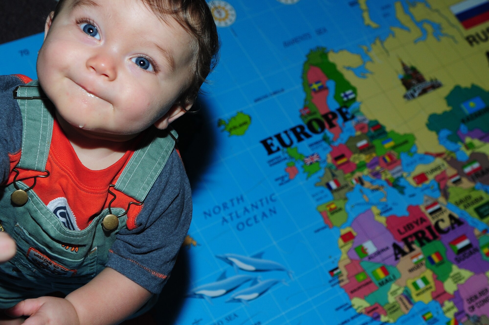 BARKSDALE AIR FORCE BASE, La. – Tristan Mills, 9 months, son of Staff Sgt. Daniyel Mills, 608th Air Communications Squadron plays on a map of the world during the third annual Barksdale Multicultural Day held at Hoban Hall July 30. The event had many craft projects for children including: Native American headbands, Japanese fans, African masks and Day of the Dead masks. (U.S. Air Force photo by Senior Airman Joanna M. Kresge)