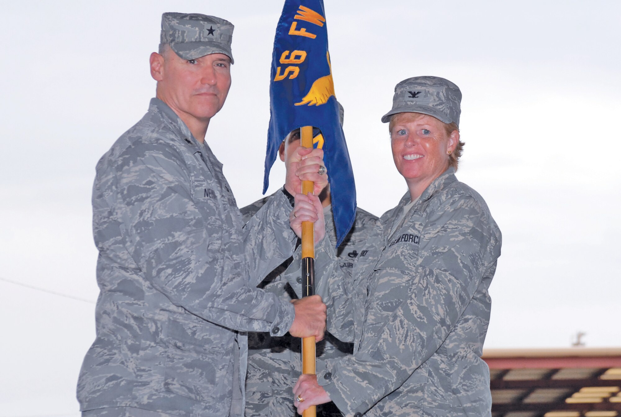 Brig. Gen. Kurt Neubauer, 56th Fighter Wing commander, passes the guidon to Col. Deborah Liddick, incoming 56th  Maintenance Group commander, July 23th during a change-of-command ceremony held in Hangar 913 on Luke Air Force Base, Arizona.  (U.S. Air Force photo/Airman 1st Class Sandra Welch)