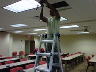 A Reservist with the 916th Communication Squadron places the wires as part of an interactive conference room at MacDill Air Force Base, Fla. (USAF photo courtesy of 916CS)