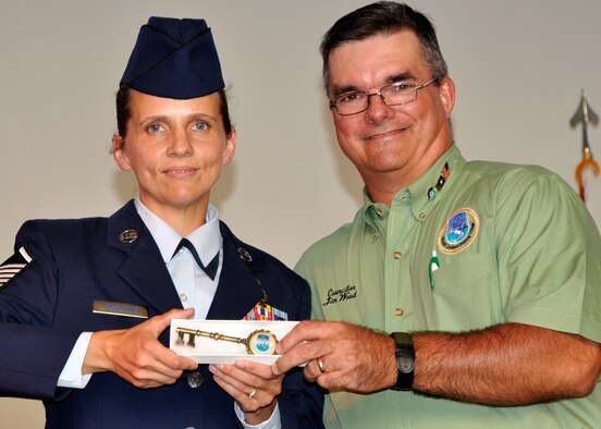 Master Sgt. April L. Pastorius, 33rd Fighter Wing communication security account manager, receives a key to Destin from Jim Wood, city councilman, during the Red, White and Blue Celebration July 29.  As one of three Airmen to be selected from Eglin, Sergeant Pastorius was recognized as a local hero during the annual event for her extensive military service.  (U.S. Air Force Photo/Jasmine DeNamur)