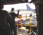 A member of the 71st observes Staff Sgt. William A. Frazer as he guides the driver of the K-loader towards the KC-135 to load cargo onto the aircraft on the 916th flightline.(USAF photo by Mr. Wayne Wuori, 916 ARW/MXS)