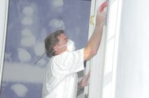 Senior Master Sgt. Barry Bradley, 916th ARW boom operator, sands a wall for a Habitat for Humanity house. (USAF photo by SSgt. Terrica Jones, 916ARW/PA)