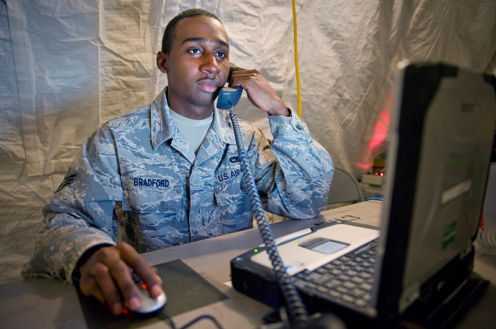 Senior Airman Matthew Bradford, deployed from the 32nd Combat Communications Squadron, assists a customer over the phone with a trouble ticket during New Horizons Panama 2010. (U.S. Air Force photo/Tech. Sgt. Sean Worrell)
