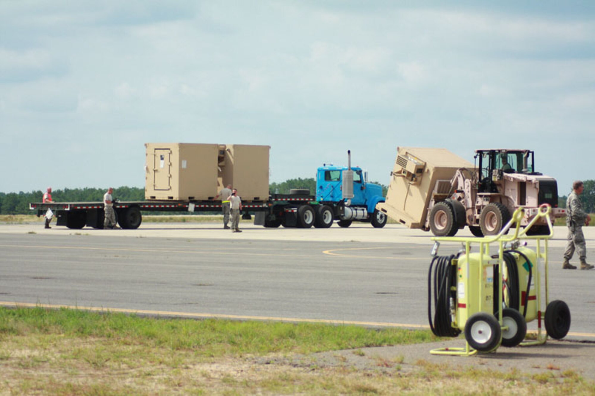 Soldiers and Airmen from exercise Eagle Flag offload pallets of food, water and shelter to be distributed to simulated local villages in a country needing humaniatiran assistance at Joint Base McGuire-Dix-Lakehurst, N.J. July 27.  (U.S. Air Force photo by Master Sgt. Phil Speck/Released)
