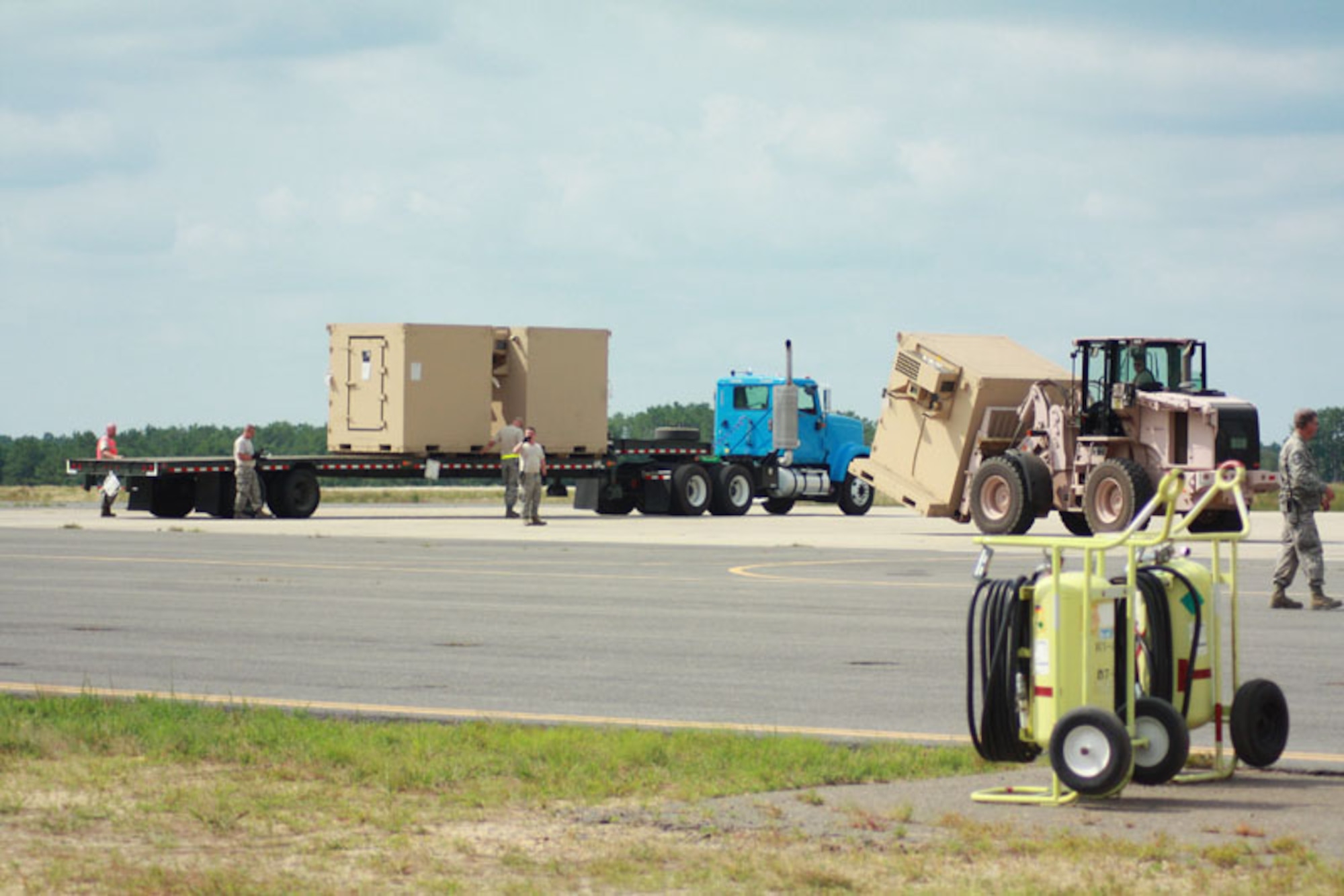 Soldiers and Airmen from exercise Eagle Flag offload pallets of food, water and shelter to be distributed to simulated local villages in a country needing humaniatiran assistance at Joint Base McGuire-Dix-Lakehurst, N.J. July 27.  (U.S. Air Force photo by Master Sgt. Phil Speck/Released)
