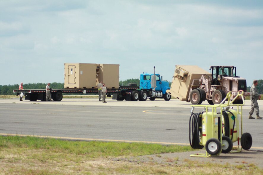 Soldiers and Airmen from exercise Eagle Flag offload pallets of food, water and shelter to be distributed to simulated local villages in a country needing humaniatiran assistance at Joint Base McGuire-Dix-Lakehurst, N.J. July 27.  (U.S. Air Force photo by Master Sgt. Phil Speck/Released)
