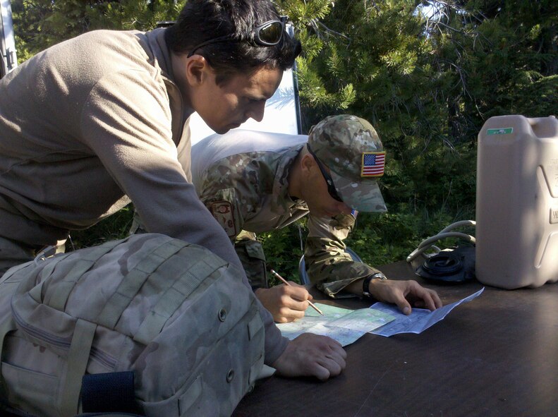 PORTLAND, Ore. - Two Air Force Reserve pararescuemen (Pjs) from the 304th Rescue Squardon, a geographically seperated unit from the 920th Rescue Wing, Cocoa Beach, Fla., map out an area to search for a missing hikier. The PJs were called in to help find a 57 year-old man reported missing after a three-day hike. The terrain, rugged and dense, required the special skills the PJs have to search the high-angle, rough area 10 miles South of Mt. Hood. The 920th RQW PJs are ready for any type of rescue in any terrain.  In fact, they are among the most highly trained emergency trauma specialists in the U.S. military. They must maintain an emergency medical technician-paramedic qualification throughout their careers. With this medical and rescue expertise, along with their deployment capabilities, PJs are able to perform life-saving missions in the world?s most remote areas. (U.S. Air Force photo)