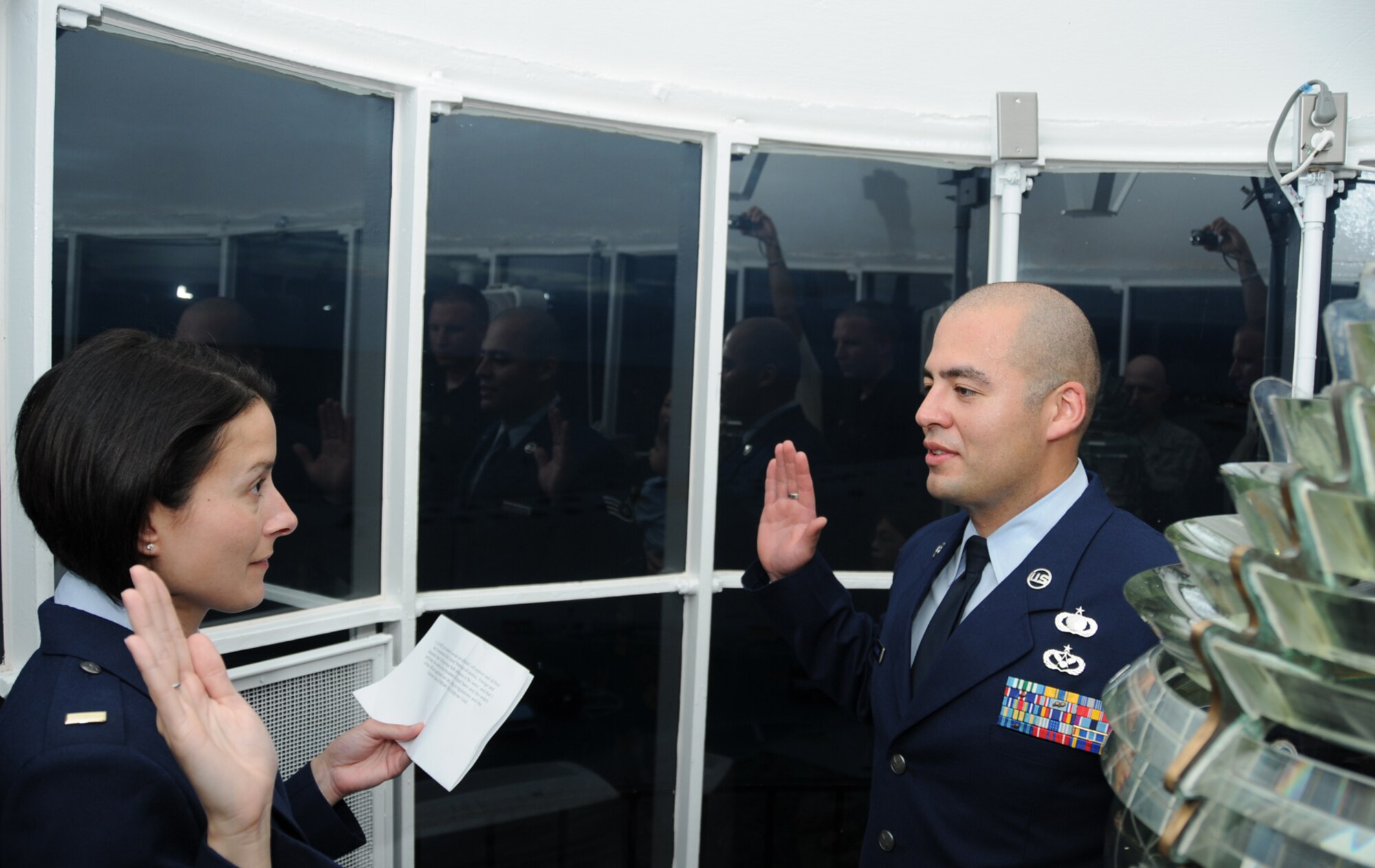 Staff Sgt. Jesus Gutierrez, 81st Contracting Squadron, right, raises his hand 
to 2nd Lt Alexandra Gamiere, July 27 as he takes the Air Force oath to 
reenlist inside the Biloxi Lighthouse in front of family and friends. 
Sergeant Gutierrez chose the symbolic lighthouse for his ceremony to honor the 
strength and spirit of the Gulf Coast community he witnessed after the 
devastation of Hurricane Katrina. Sergeant Gutierrez leaves for Ramstein Air 
Base, Germany next month after more than eight years at Keesler.  (U.S. Air Force photo by Kemberly Groue)
