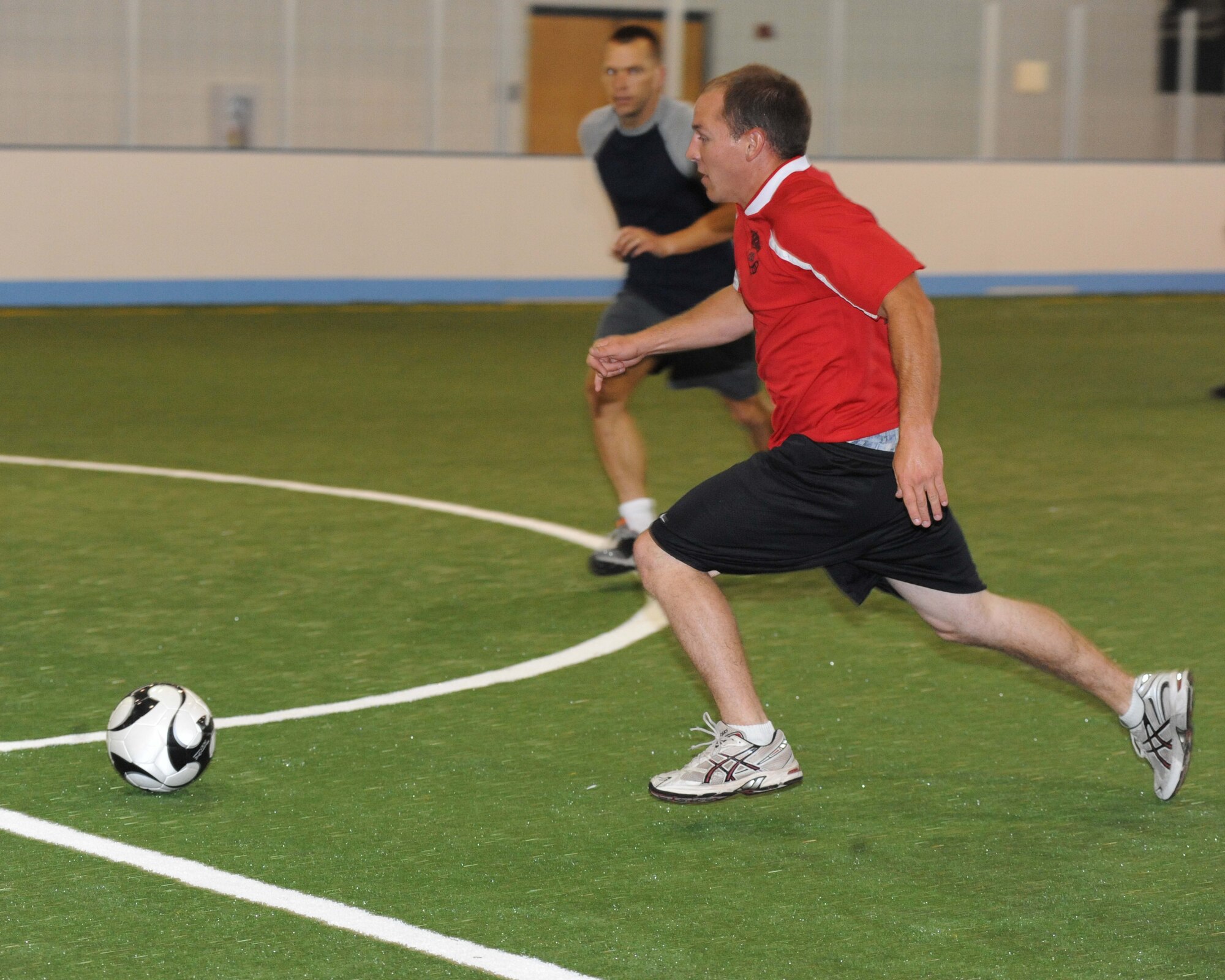 Airman 1st Class Garin T. Pisano, 319th Civil Engineer Squadron, races toward the ball during a soccer tournament July 28 at the Grand Forks Air Force Base Fitness Center.  The tournament was held after an official ribbon cutting ceremony for the fitness center’s new turf surface. The 319th Maintenance Group beat the 319th CES 4-3 in the championship game. (U.S. Air Force photo by Airman 1st Class Amber Price)