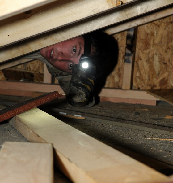 MOODY AIR FORCE BASE, Ga. -- Senior Airman Joseph Mott, 38th Rescue Squadron pararescueman, removes debris from a simulated collapsed building structure during confined spaces training here July 29. Personnel from the 38th RQS had to safely maneuver their way through debris and furniture using search and rescue equipment to extract a simulated trapped victim. (U.S. Air Force photo by Airman 1st Class Benjamin Wiseman/RELEASED)