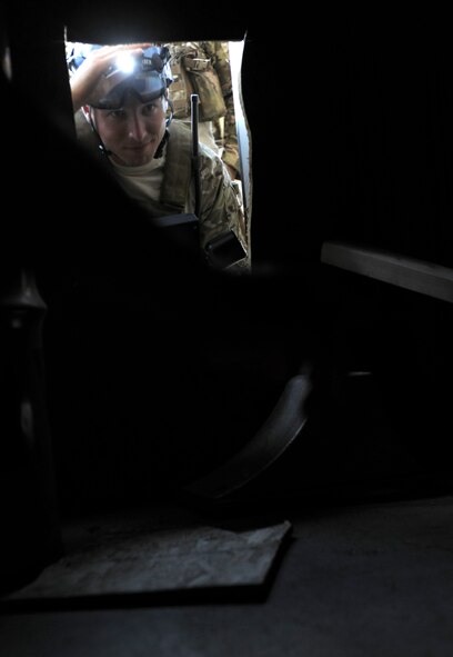 MOODY AIR FORCE BASE, Ga. -- Senior Airman Joshua Cunningham, 38th Rescue Squadron pararescueman, starts to crawl through a hole during confined spaces training here July 29. Airman Cunningham checked around the building to ensure that the structure was sturdy before continuing his search inside the structure. (U.S. Air Force photo by Airman 1st Class Benjamin Wiseman/RELEASED)