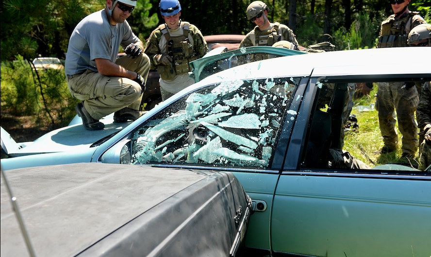 VALDOSTA, Ga. -- Pararescuemen from the 38th Rescue Squadron from Moody Air Force Base, Ga., were instructed to work through different scenarios during a confined spaces exercise at a local junkyard here July 27. The task required the 38th RQS members to maneuver through smashed vehicles of a simulated car accident, forcing them to apply their newly-learned techniques to gain access through one car to get to another. (U.S. Air Force photo by Airman 1st Class Joshua Green/RELEASED)
