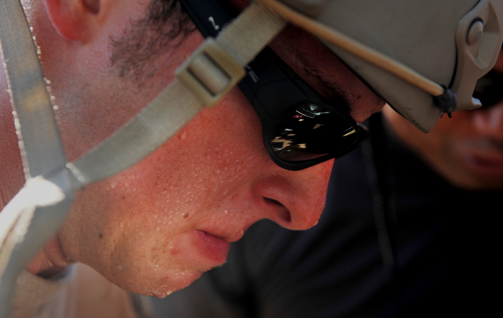 VALDOSTA, Ga. -- Senior Airman Joseph Mott, 38th Rescue Squadron pararescueman from Moody Air Force Base, Ga., sweats during a confined spaces exercise at a local junkyard here July 27. Airman Mott was in the process of prying a door off its hinges using a “Jaws of Life” machine. (U.S. Air Force photo by Airman 1st Class Joshua Green/RELEASED)
