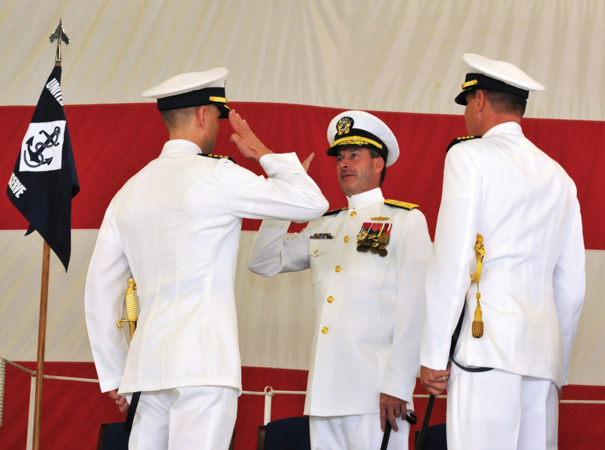 Captain Timothy Fox, commanding officer of Naval Air Facility Washington, renders a salute to Rear Adm. Buzz Little in part of the transfer of command to Capt. Randolph B. Johnson on July 24. Captain Johnson relieved Captain Fox as commanding officer at the ceremony.  The change of command ceremony is a time-honored tradition that formally restates to the officer and enlisted sailors of the command the continuity of the authority of command. (Photo by MC2(AW/SW) Clifford L. H. Davis)