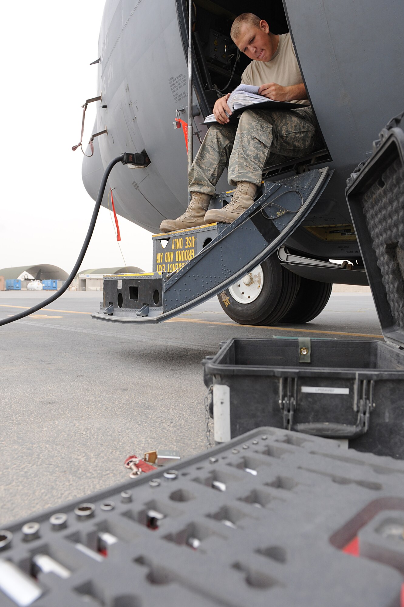 Senior Airman Joshua Johnston, a communications and navigation mission systems journeyman assigned to the 451st Expeditionary Aircraft Maintenance Squadron, Kandahar Airfield, Afghanistan, reviews technical orders while troubleshooting a faulty component in a C-130J July 30, 2010.  Airman Johnston is deployed from Little Rock Air Force Base, Ark.(U.S. Air Force photo by Staff Sgt. Chad Chisholm/Released)