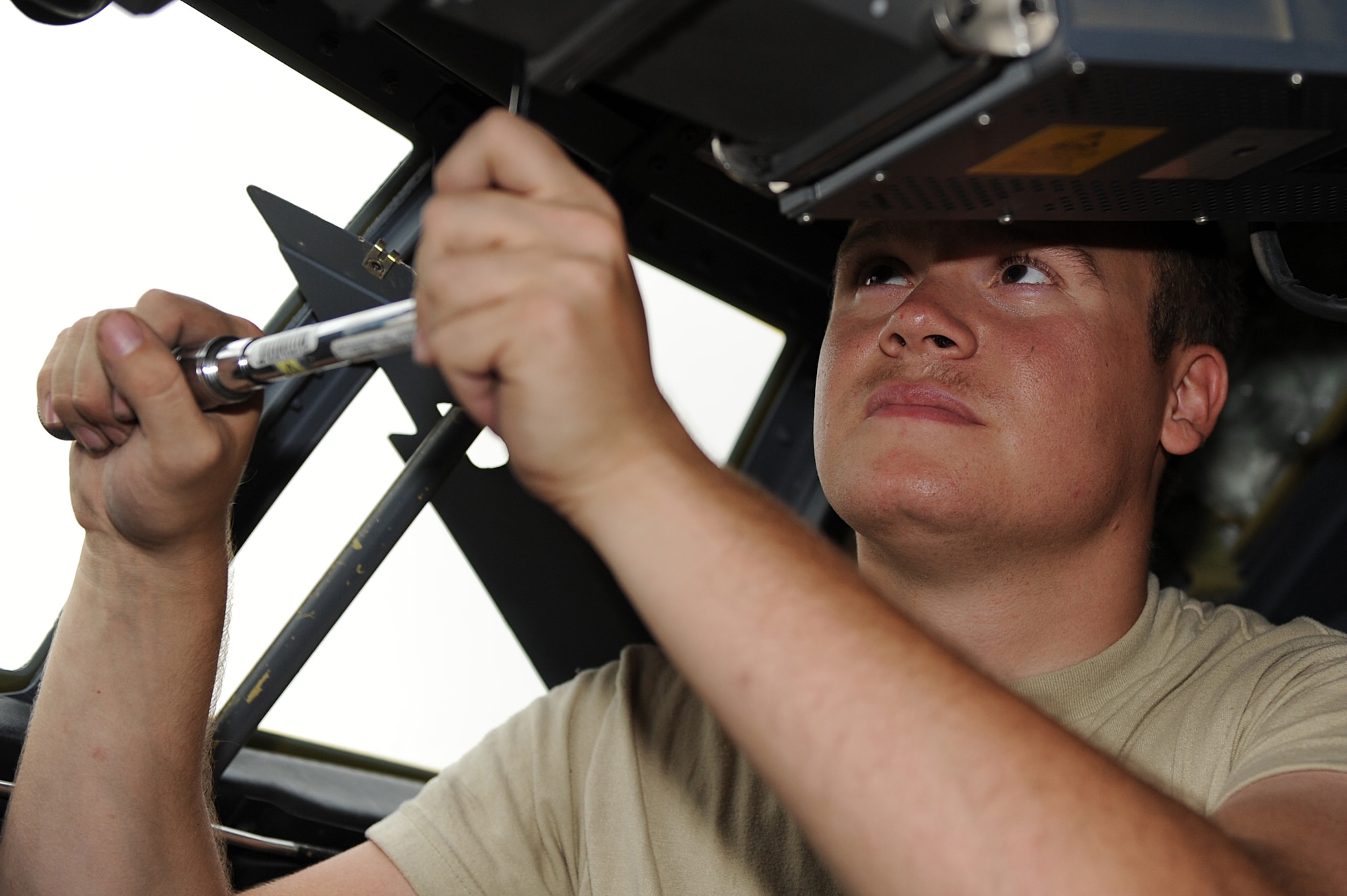 Senior Airman David Ortega, an integrated flight control system journeyman assigned to the 451st Expeditionary Aircraft Maintenance Squadron, Kandahar Airfield, Afghanistan, precisely tightens a bolt on a C-130J Hercules electronic instrument box July 30, 2010. Airman Ortega is deployed from Little Rock Air Force Base, Ark. (U.S. Air Force photo by Staff Sgt. Chad Chisholm/Released)