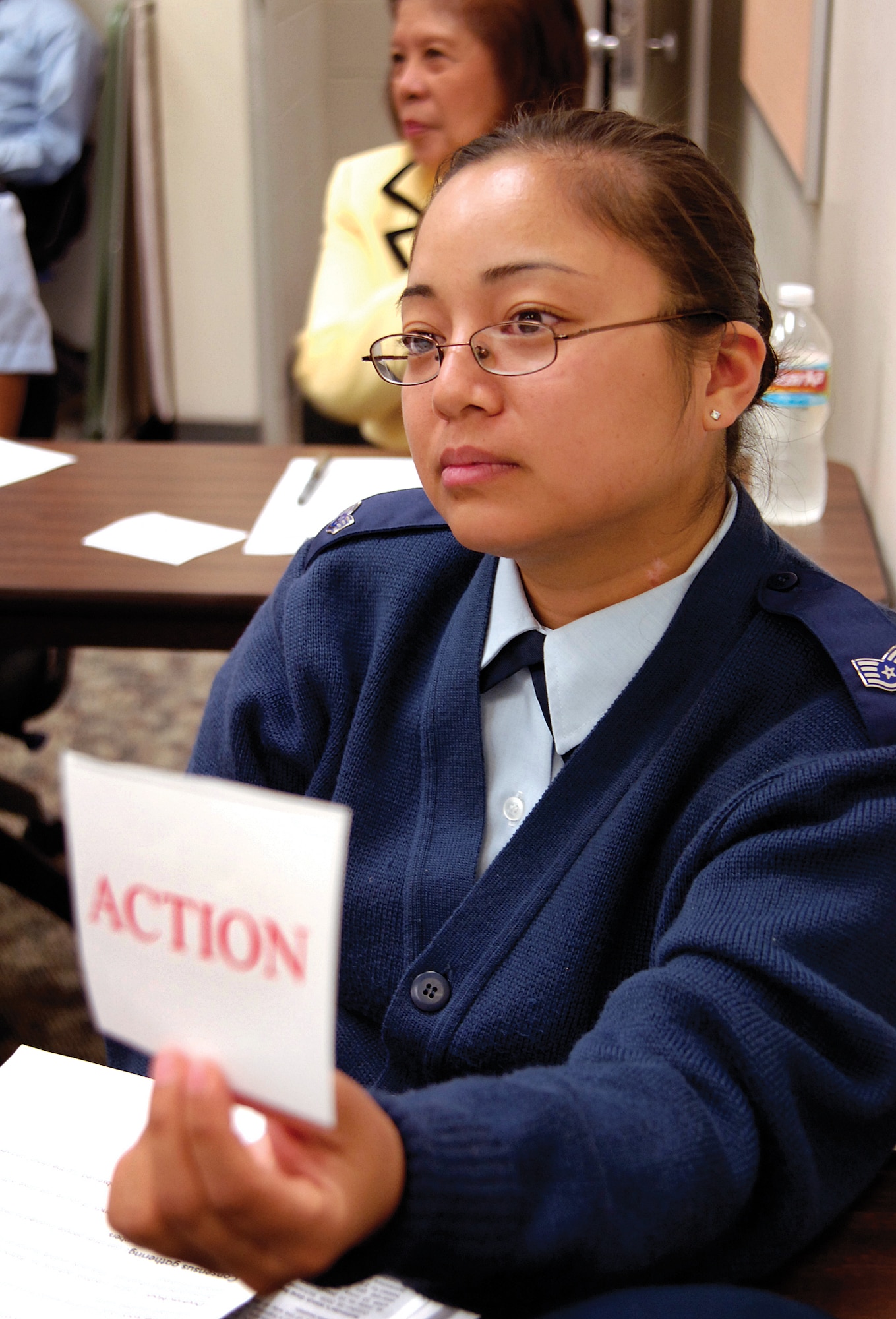 Staff Sgt. Mariza Fox, raises her ACTION card during the bystander intervention training class, indicating action is needed to a scenario outlined by the instructor. (Air Force photo by Margo Wright)