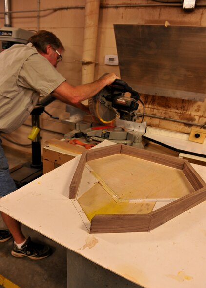 MOODY AIR FORCE BASE, Ga. -- Jim Connelly, Wood Shop supervisor, cuts out specific shapes to fit a stencil design of a shadow bow here July 9. To get the shape of the Air Force insignia, every piece has to be cut at a certain angle and then put together with glue and nails. (U.S. Air Force photo by Airman 1st Class Joshua Green/RELEASED)