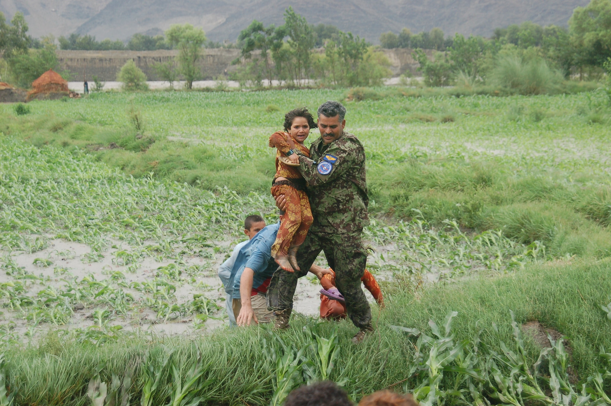 Lt. Col. Bahadur, Afghan Air Force rescues a small child on July 29, 2010 when the Afghan Air Force responded with two Mi-17s and aircrew accompanied by United States Air Force Air Advisors to an urgent request to begin rescuing people overcome by rapidly rising flood waters at the confluence of the Kabul and Laghman Rivers, about 11 miles west of Jalalabad.  Over 2,100 people were saved, by the AAF and their Mi-17s from the high threat raging flood waters most of them under the threat of foreign insurgent fighters.  (Courtesy photo by Maj. Kazim, Afghan Air Force/RELEASED).
