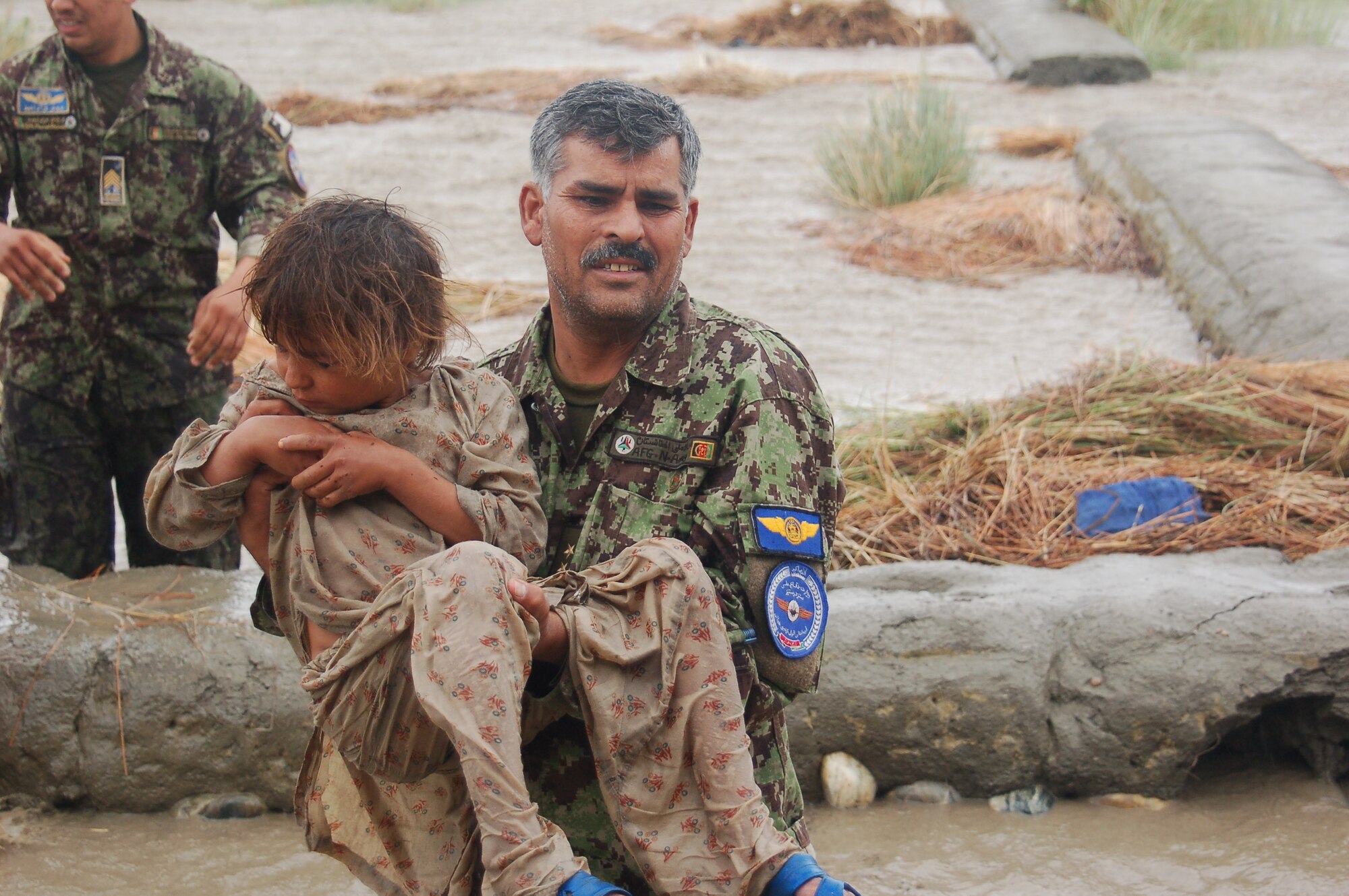 Lt. Col. Bahadur, Afghan Air Force rescues a small child on July 29, 2010 when the Afghan Air Force responded with two Mi-17s and aircrew accompanied by United States Air Force Air Advisors to an urgent request to begin rescuing people overcome by rapidly rising flood waters at the confluence of the Kabul and Laghman Rivers, about 11 miles west of Jalalabad.  Over 2,100 people were saved, by the AAF and their Mi-17s from the high threat raging flood waters most of them under the threat of foreign insurgent fighters.  (Courtesy photo by Maj. Kazim, Afghan Air Force/RELEASED).