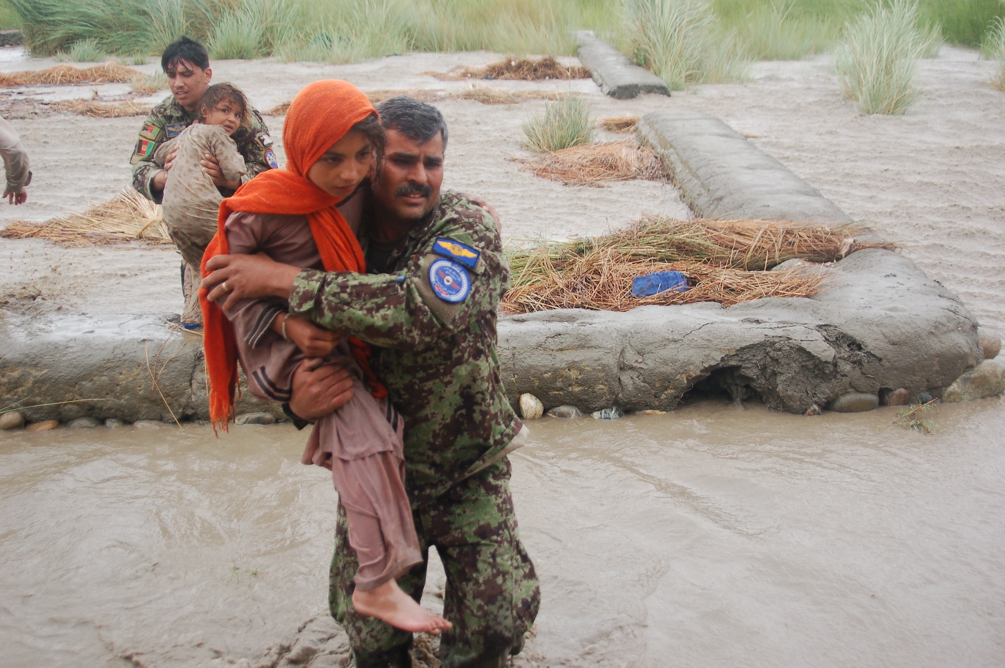 Lt. Col. Bahadur, Afghan Air Force rescues a small child on July 29, 2010 when the Afghan Air Force responded with two Mi-17s and aircrew accompanied by United States Air Force Air Advisors to an urgent request to begin rescuing people overcome by rapidly rising flood waters at the confluence of the Kabul and Laghman Rivers, about 11 miles west of Jalalabad.  Over 2,100 people were saved, by the AAF and their Mi-17s from the high threat raging flood waters most of them under the threat of foreign insurgent fighters.  (Courtesy photo by Maj. Kazim, Afghan Air Force/RELEASED).