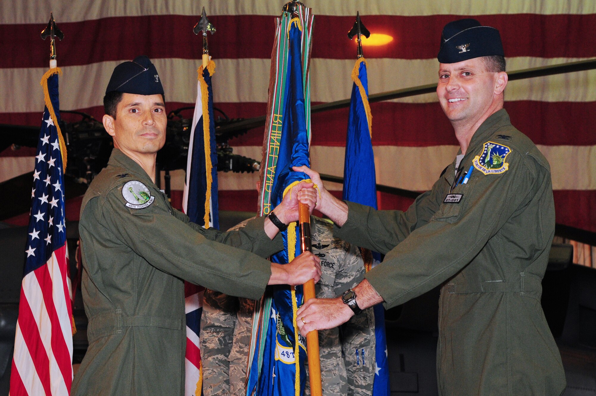 Col. John Quintas, 48th Fighter Wing commander, passes the 48th Operations Group guidon to Col. Daniel Orcutt as he assumes command, July 30, at Hanger 7 on RAF Lakenheath. As commander, he will oversee the operations of three combat-ready squadrons of F-15E Strike Eagle and F-15C Eagle fighter aircraft and an HH-60G combat search and rescue squadron. (U.S. Air Force photo/Airman 1st Class Lausanne Morgan)