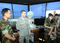 KUNSAN AIR BASE, Republic of Korea -- Republic of Korea Air Force Master Sgt. Cha Dong Hyun, ROKAF air traffic controller and liaison to the 8th Operations Support Squadron, and Senior Airman Matthew Shapley, 8th OSS air traffic controller, answer questions from ROK students from Jik Island during a visit here July 29. The students also toured the Armed Forces Network Korea facility here during their visit. The visit was documented by both AFN and the Korean Forces Network. (Republic of Korea Air Force photo/Courtesy photo)