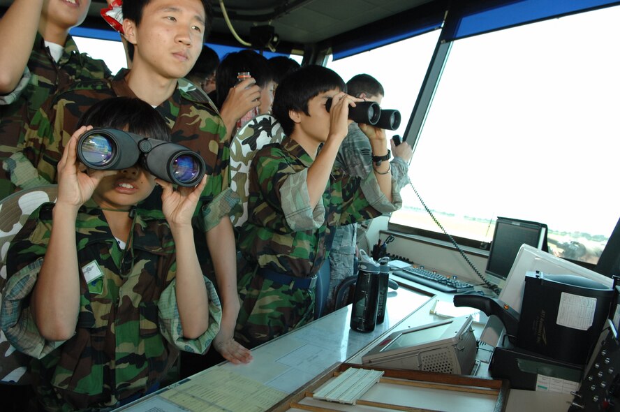 KUNSAN AIR BASE, Republic of Korea -- Republic of Korea students from Jik Island look through binoculars in the 8th Operations Support Squadron air traffic control tower during their visit here July 29. The students also toured the Armed Forces Network Korea facility here during their visit. The visit was documented by both AFN and the Korean Forces Network. (Republic of Korea Air Force photo/Courtesy photo)