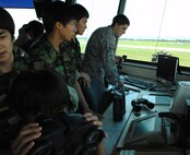 KUNSAN AIR BASE, Republic of Korea -- Senior Airman Timothy Scott, 8th Operations Support Squadron air traffic controller, records an Automated Terminal Information Service message during a visit from Republic of Korea students from Jik Island July 29. The students also toured the Armed Forces Network Korea facility here during their visit. The visit was documented by both AFN and the Korean Forces Network. (Republic of Korea Air Force photo/Courtesy photo)
