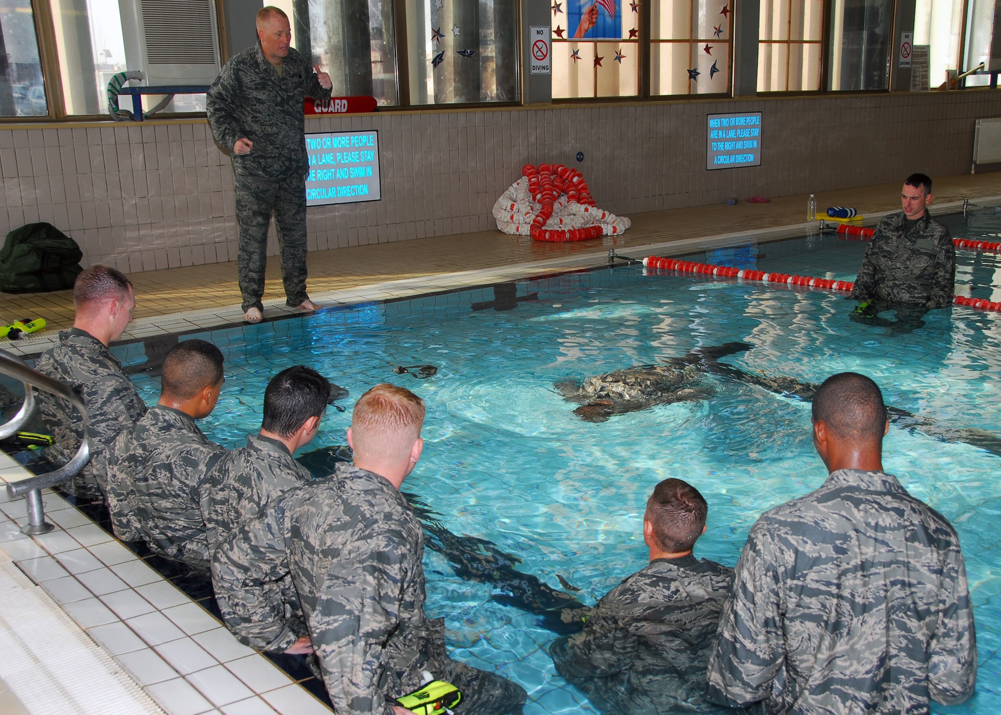 Tech. Sergeant David Walker, 532nd Expeditionary Security Forces Squadron operations plans and programs manager, explains how to remove body armor under water during water egress training July 23, 2010, at Joint Base Balad, Iraq. Water egress is a critical part of Relief in Place/ Transfer of Authority training; it teaches Airman how to stay alive if a vehicle were to overturn into water while on patrol. Sergeant Walker is deployed from McDill Air Force Base, Fla., he is a native of Cocoa, Fla. (U.S. Air Force photo/Senior Airman Marianne E. Lane)