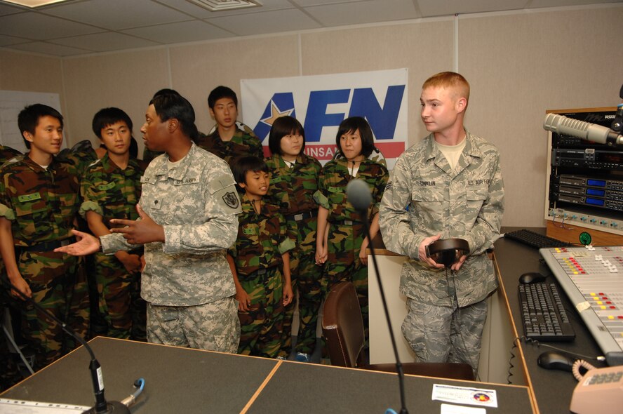 KUNSAN AIR BASE, Republic of Korea -- Specialist Sabrina Black and Senior Airman Steve Conklin, Armed Forces Network Korea at Kunsan, talk about working in the AFN radio studio to Republic of Korea students from Jik Island who visited here July 29. The students also toured the 8th Operations Support Squadron air traffic control tower during their visit. The visit was documented by both AFN and the Korean Forces Network. (Republic of Korea Air Force photo/Courtesy photo)