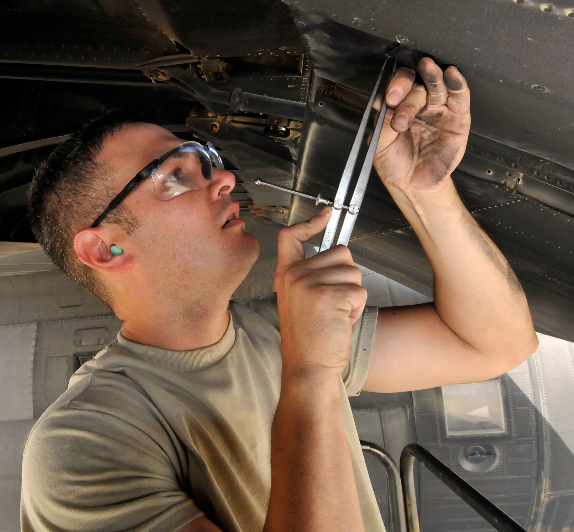Staff Sgt. Francisco Velasquez, 332nd Expeditionary Maintenance Squadron aircraft structural maintenance craftsman, measures the distance from the edge of a C-130 Hercules wing baffle to the edge of a crack July 24, 2010, Joint Base Bald, Iraq.  Accurate measurements are crucial, when fixing aircraft structural imperfections. Sergeant Velasquez is a native of Monroe, Mich., deployed from Little Rock Air Force Base, Ark. (U.S. Air Force photo/Staff Sgt. Phillip Butterfield)