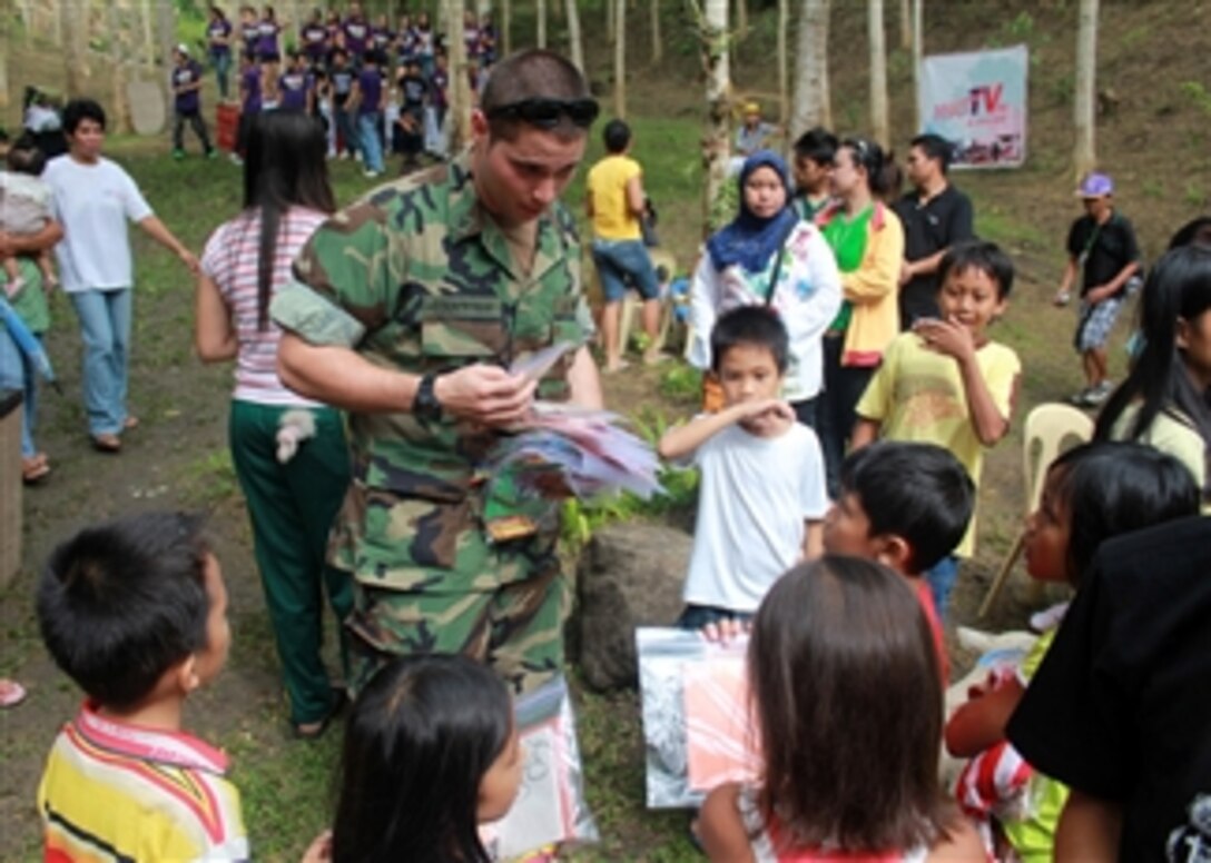 U.S. Navy Petty Officer 3rd Class Timothy Countryman hands out crayons and coloring books to Philippine children during a medical civic action project at Lantawan, in Zamboanga City, Philippines, on July 24, 2010.  The project was conducted by Armed Forces of the Philippines soldiers from Western Mindanao Command, 3rd Air Division and Task Force Zamboanga, which also invited local doctors and area nursing students to participate.  More than 300 people received medical and dental care during the event.  