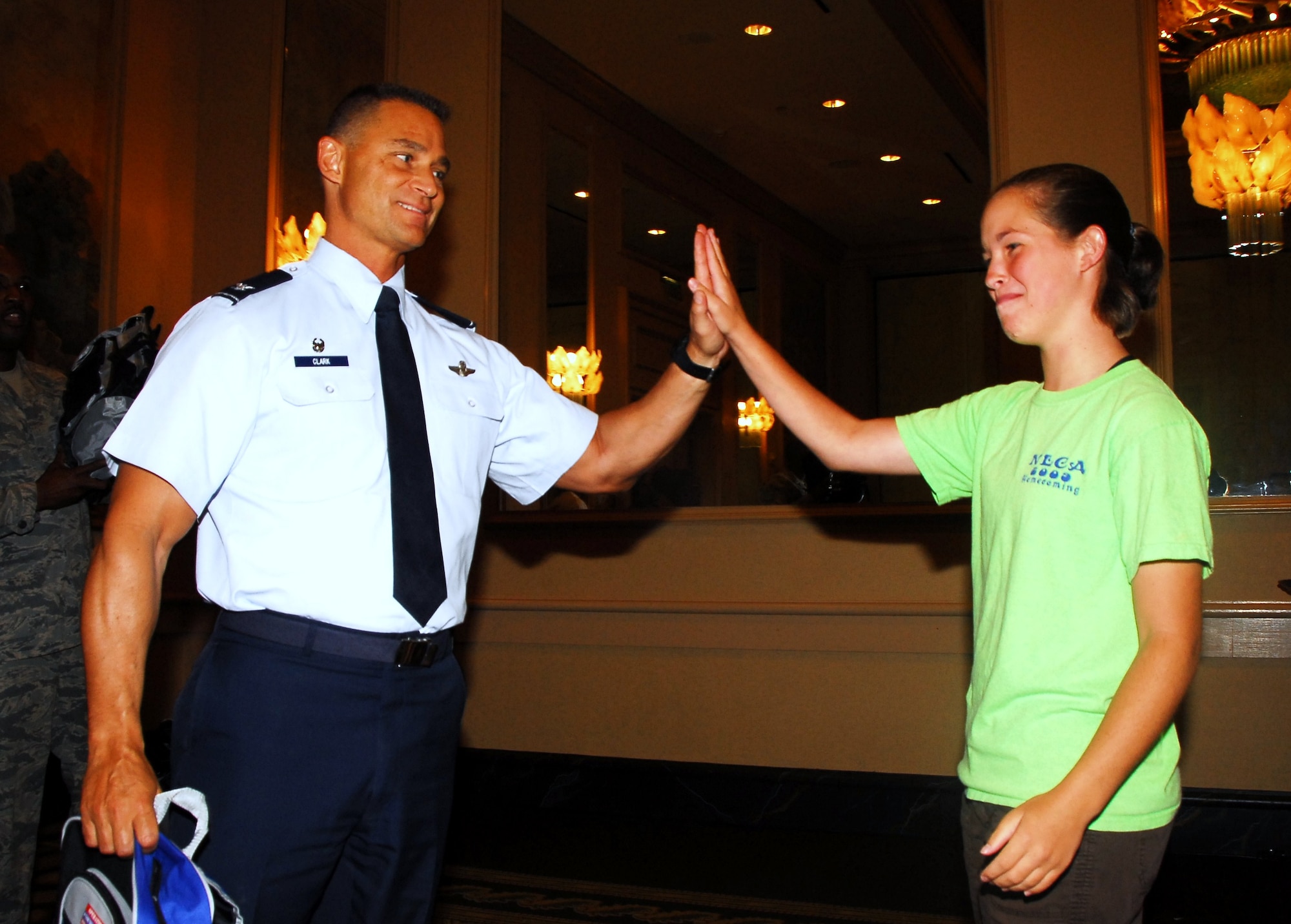 The 908th Airlift Wing hosted a Yellow Ribbon event in Birmingham, Ala. for families of deployed members. Above, Wing commander Col. Brett Clark high fives a deployers' daughter before giving her a gift backpack. (Air Force photo by Lt. Col. Jerry Lobb)