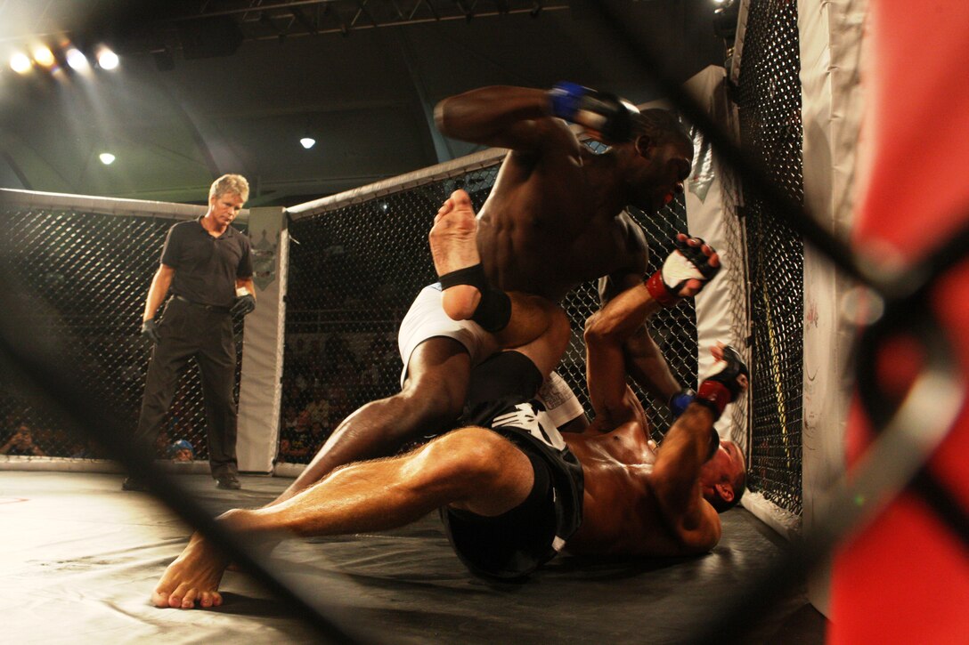 Derek Brunson (top), of Team Evolution Mixed Martial Arts, strikes Ed Jackson, of Team Strikers Union, during the Sacred Ground Mixed Martial Arts event at Goettge Memorial Field House aboard Marine Corps Base Camp Lejeune, July 31.