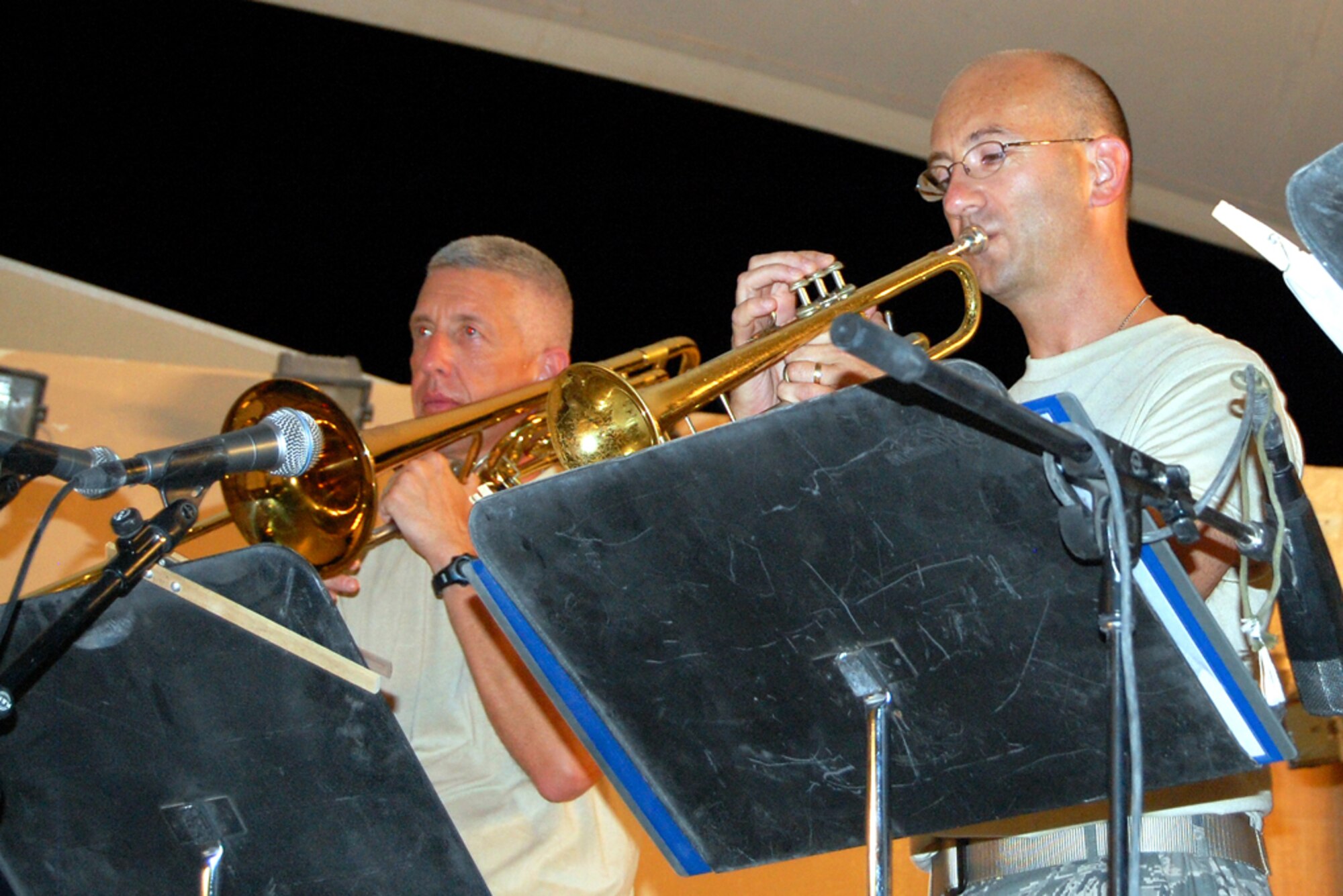 From left, U.S. Airmen Master Sgt. Tony Cyrus and Maj. Bryan Miller, both U.S. Air Forces Central Band New Directions members, play brass during a performance for the 379th Airlift Wing at a base in Southwest Asia July 26, 2010. Sergeant Cyrus and Major Miller are deployed from the Air National Guard Band of the Northeast at Milford, Mass. The band’s mission is to create musical events designed to uplift morale and build positive internal and external relationships. New Horizons is scheduled to perform nearly 25 times until the middle of August throughout the U.S. Central Command area of responsibility. (U.S. Air Force photo by Maj. Chad Steffey/Released)