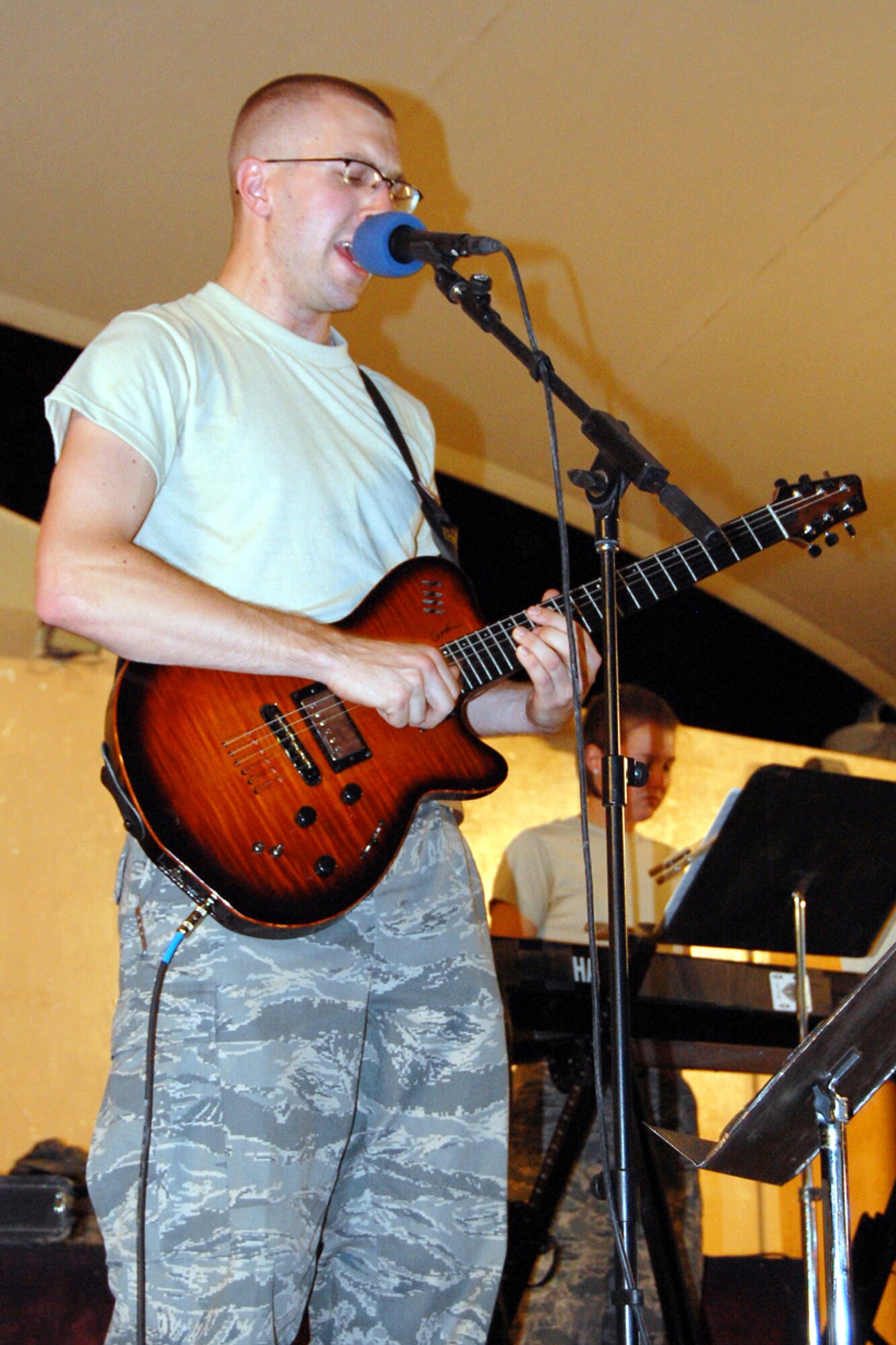 U.S. Air Force Senior Airman Kevin Klepacki, U.S. Air Forces Central Band New Directions, sings and plays guitar during a performance for the 379th Airlift Wing at a base in Southwest Asia July 26, 2010. Airman Klepacki is deployed from the Air National Guard Band of the Northeast at Milford, Mass. The band’s mission is to create musical events designed to uplift morale and build positive internal and external relationships. New Horizons is scheduled to perform nearly 25 times until the middle of August throughout the U.S. Central Command area of responsibility. (U.S. Air Force photo by Maj. Chad Steffey/Released)