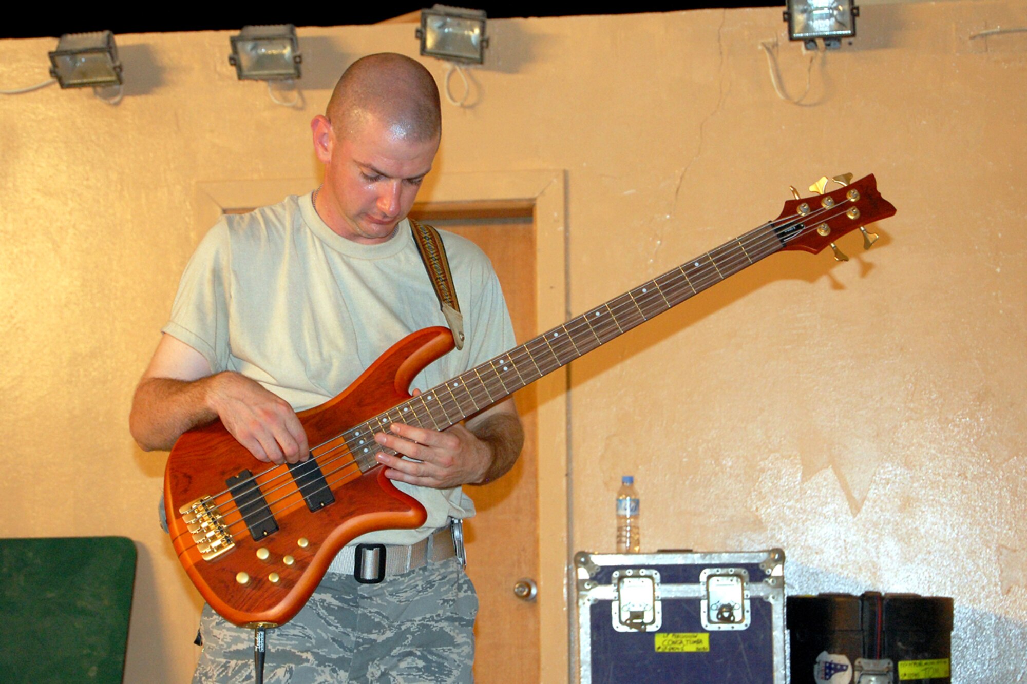U.S. Air Force Staff Sgt. Patrick Chambers, U.S. Air Forces Central Band New Directions, plays bass guitar during a performance for the 379th Airlift Wing at a base in Southwest Asia July 26, 2010. Sergeant Chambers is deployed from the Air National Guard Band of the Northeast at Milford, Mass. The band’s mission is to create musical events designed to uplift morale and build positive internal and external relationships. New Horizons is scheduled to perform nearly 25 times until the middle of August throughout the U.S. Central Command area of responsibility. (U.S. Air Force photo by Maj. Chad Steffey/Released)