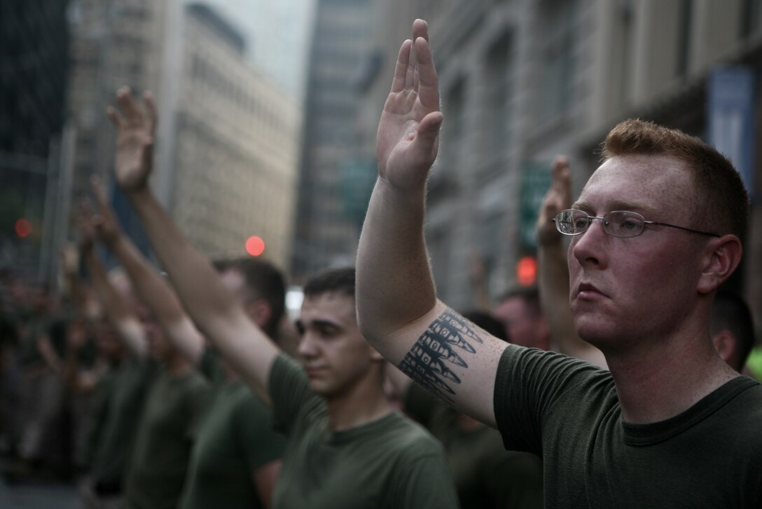 Marines with Special Purpose Marine Air Ground Task Force New York raise their hands at the World Trade Center site after their commanding officer asked who among them enlisted after the Sept. 11 terrorist attacks. The Marines joined Sailors, Coast Guardsmen, New York police and firefighters in a memorial run to Ground Zero as part of Fleet Week New York 2010.
