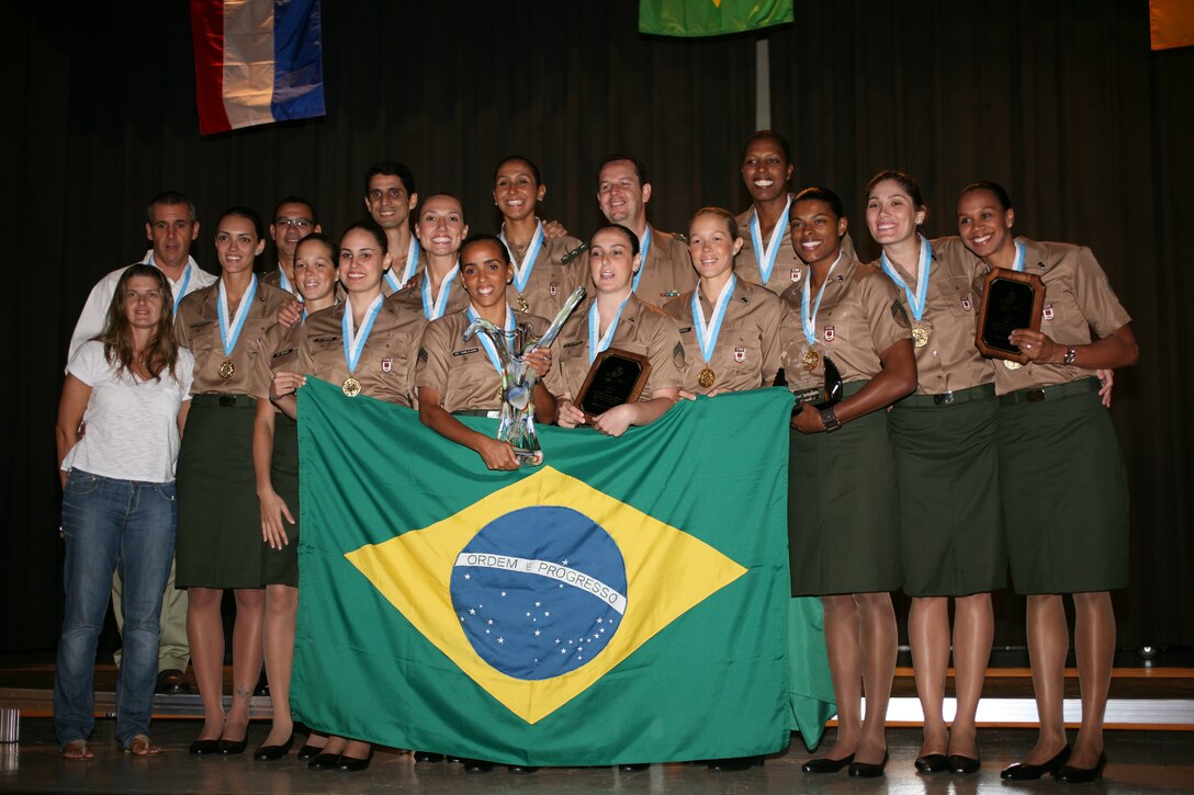 Team Brazil poses with its gold medals, the Challenge Cup, and its country ensign after the closing ceremony at the Station Theater, June 1. Brazil took the gold medal, along with the undefeated record of 3-0, never losing a set and only allowing a team to score 14 points in a set.