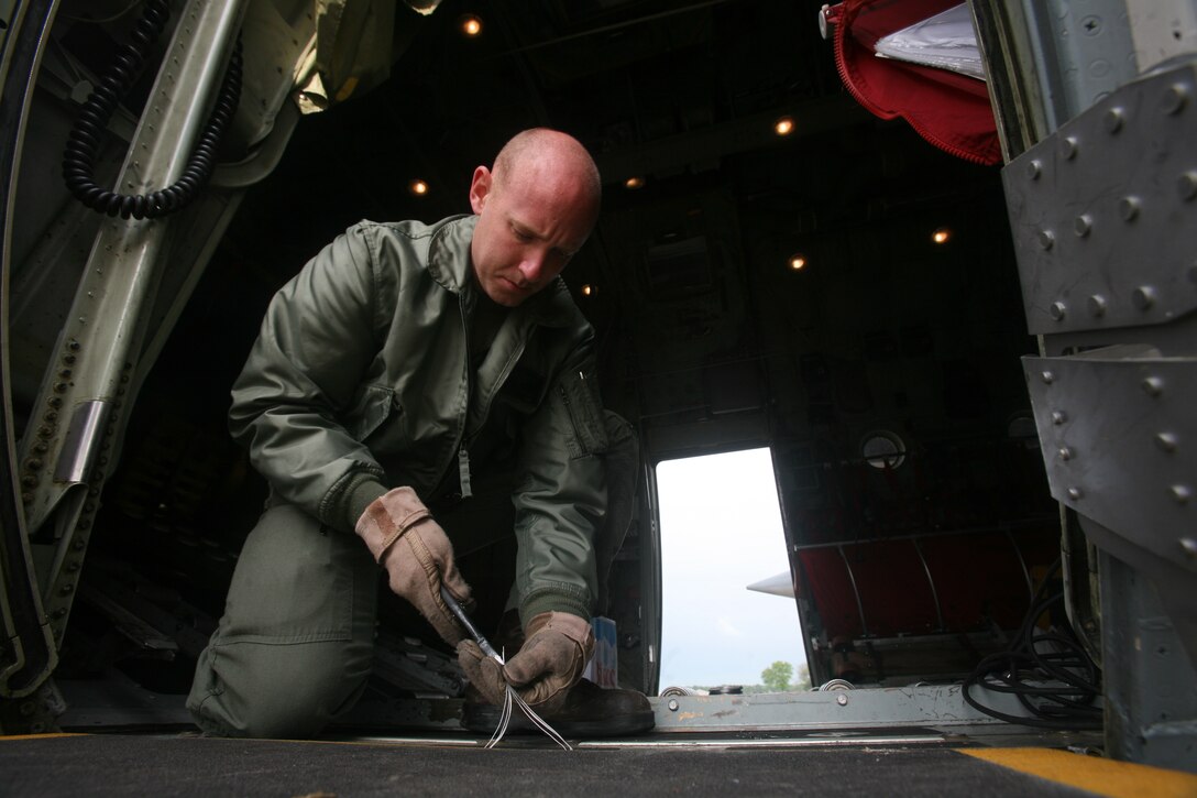 Gunnery Sgt. Robert Hopkins, a KC-130T loadmaster with Marine Aerial Refueler Transport Squadron 234, installs a jump platform on the paratroop door of a KC-130, June 2. A pair of KC-130 Hercules aircraft from VMGR-234 and VMGR-452 provided support for Romanian airborne training, June 2-3. The Marines and Romanian forces are slated to take to the skies again for more paratroop training, June 8-9.