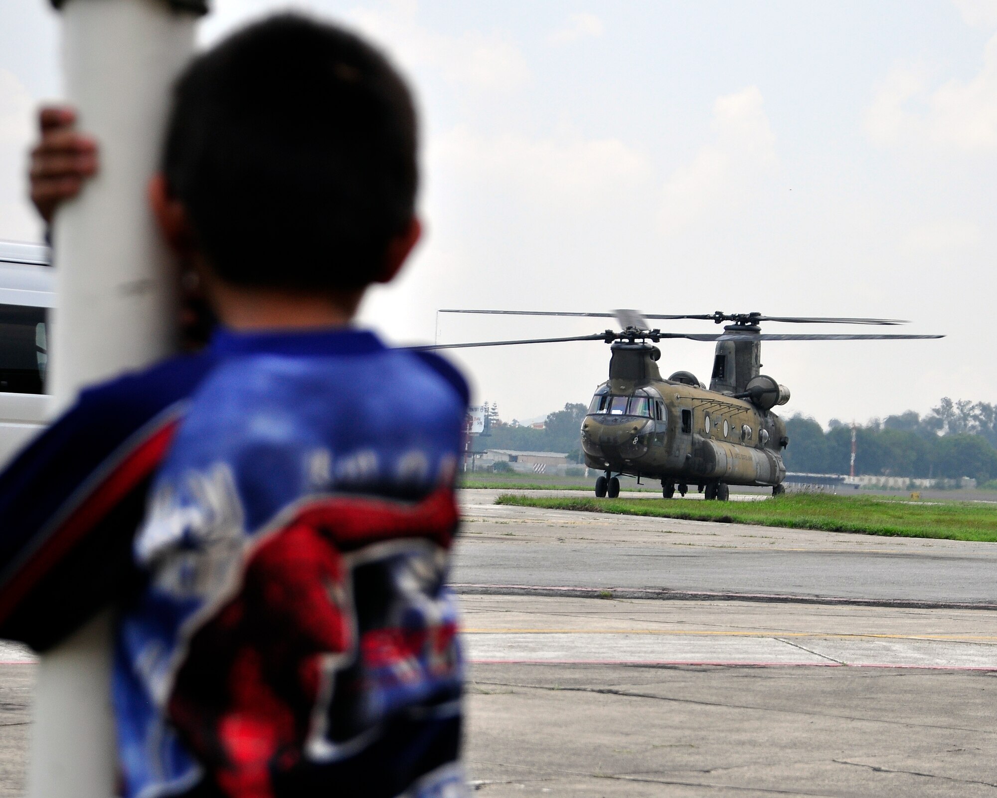 A young boy watches a CH-47 Chinook taxi away at the Guatemala City Airport after dropping off Joint Task Force-Bravo personnel June 1. At the request of the Guatemalan government, U.S. Southern Command's Joint Task Force-Bravo deployed four helicopters and more than forty personnel from Soto Cano Air Base, Honduras, to support humanitarian assistance efforts in Guatemala following Tropical Storm Agatha. (U.S. Air Force photo by Staff Sgt. Bryan Franks)