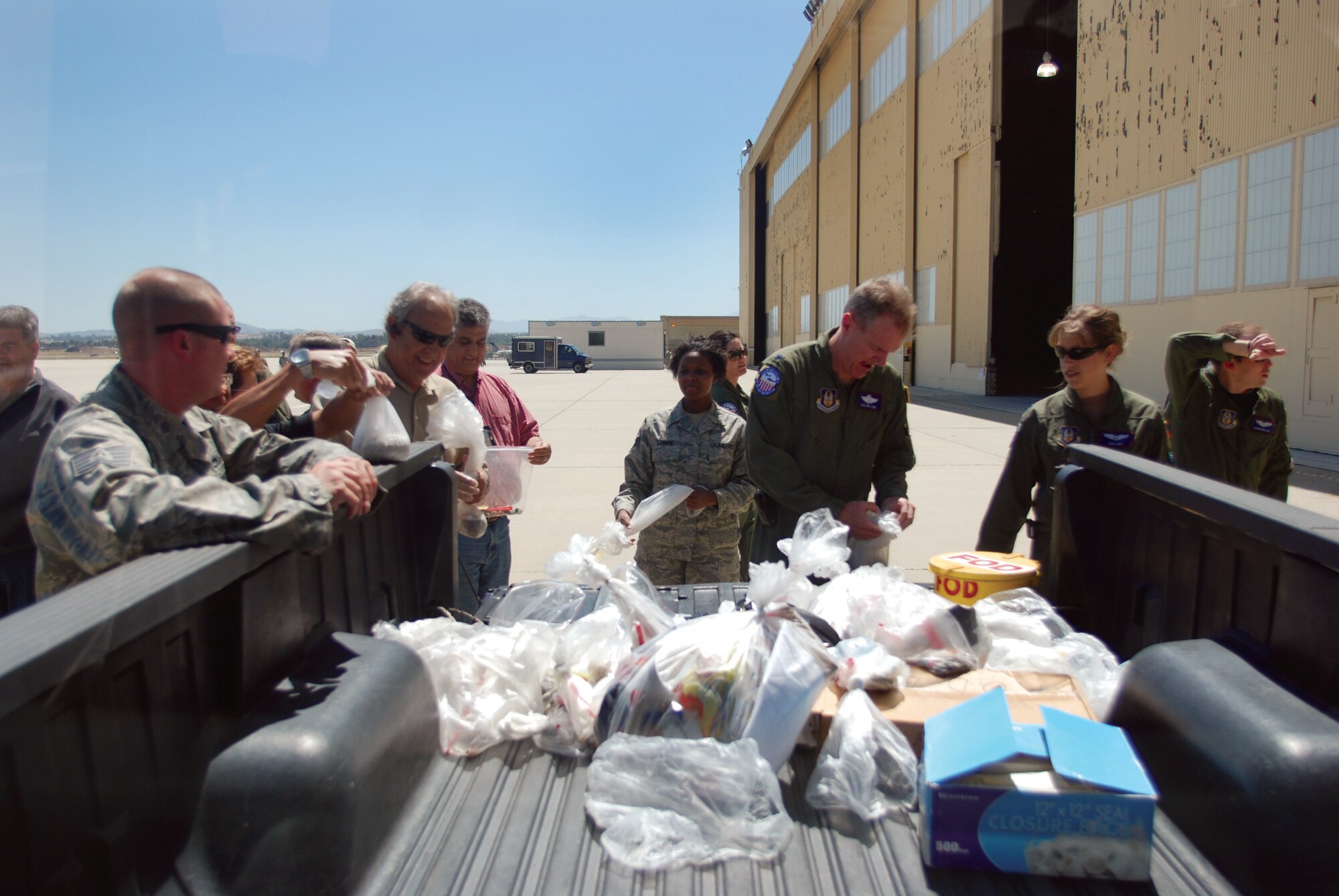 Team March members drop off bags containing trash they found on the ramp during the base-wide, after air show foreign object damage walk. "We had more people out there than I've seen before," said Master Sgt. Jeremy Knox, 452nd Maintenance Group Quality Assurance, who has been at March ARB for five years. The walkers collected a total of 65 pounds of FOD, which is triple the weight normally collected during quarterly wing FOD walks. (U.S. Air Force photo by Staff Sgt. Megan Crusher)
