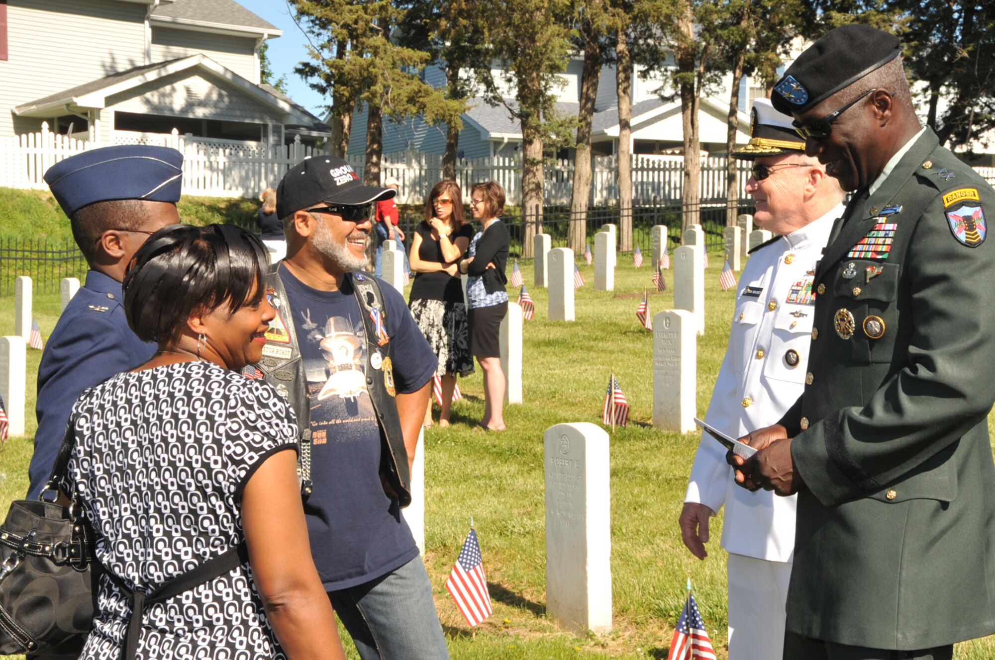 OFFUTT AIR FORCE BASE, Neb. -- Among the headstones of Offutt's cemetery, Adm. Carl V. Mauney, deputy commander of U.S. Strategic Command, in white uniform and Maj. Gen. Abraham J. Turner, USSTRATCOM chief of staff, in green uniform, greet attendees of the base's Memorial Day ceremony May 31.  More than 100 people attended the annual service. U.S. Air Force Photo by D.P. Heard