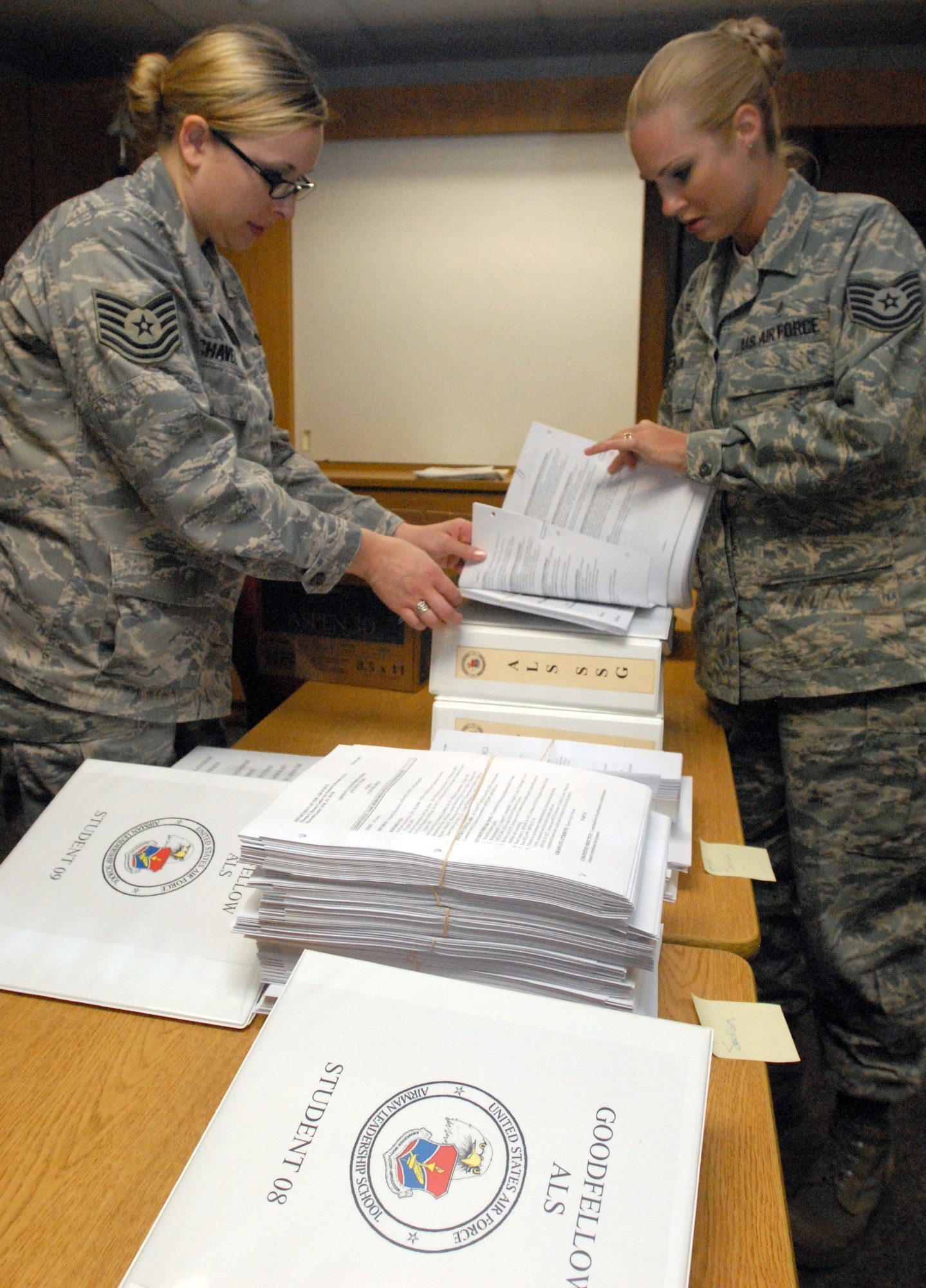 Tech.  Sgt. Jasmine Chavez, an instructor with the Dyess AFB Airman Leadership School, and Tech. Sgt. April Miller, an instructor with the Goodfellow AFB Airman Leadership School, put together student books June 1 as they gear up for the start of the first class of the Goodfellow ALS June 2.  (U.S. Air Force photo/ Master Sgt. Randy Mallard)