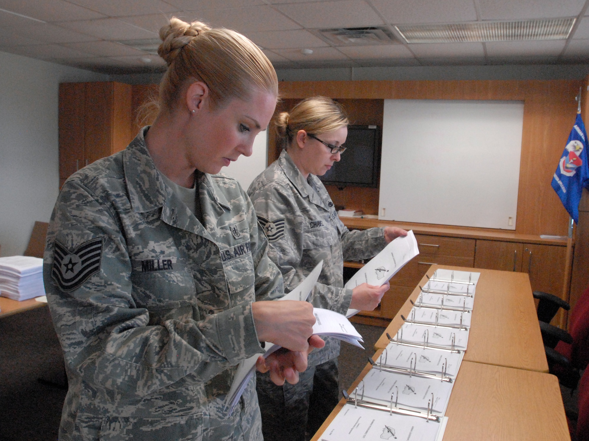 Tech. Sgt. April Miller, an instructor with the Goodfellow AFB Airman Leadership School, and Tech.  Sgt. Jasmine Chavez, an instructor from the Dyess AFB Airman Leadership School, put together student books for the start of the first class of the Goodfellow ALS, June 1.  (U.S. Air Force photo/ Master Sgt. Randy Mallard)