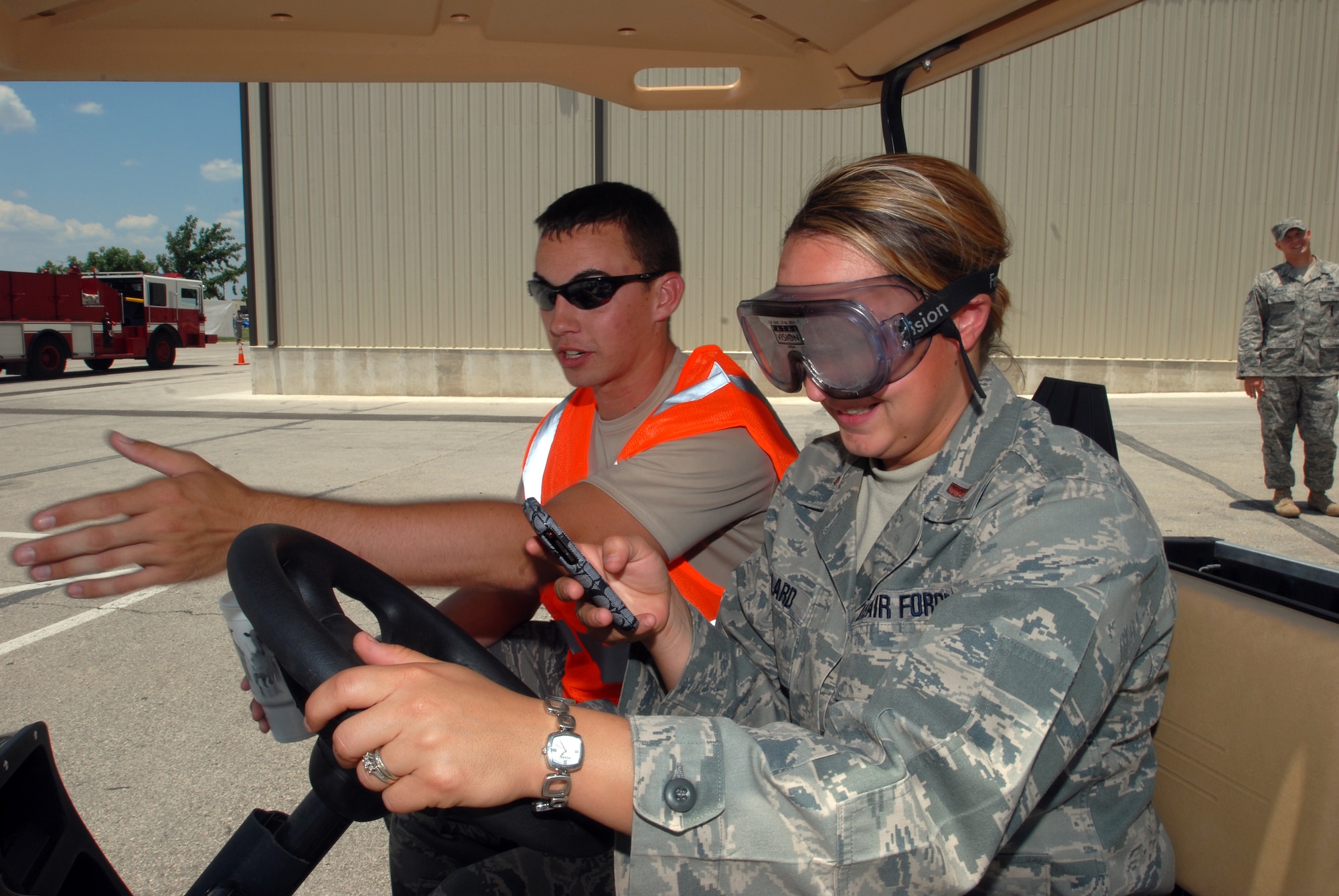Senior Airman Jeffery Hart, 17th Training Support Squadron, has 2nd Lt. Amber Bullard, 315th Training Squadron, attempt to send a text message while driving a golf cart and wearing goggles that impair her ability to see properly. Members of Goodfellow were given the opportunity to experience the consequences of bad driving habits and receive information on other safety issues during the May 28 Safety Day which marked the start of 101 Critical Days of Summer. (U.S. Air Force photo/Master Sgt. Randy Mallard) 