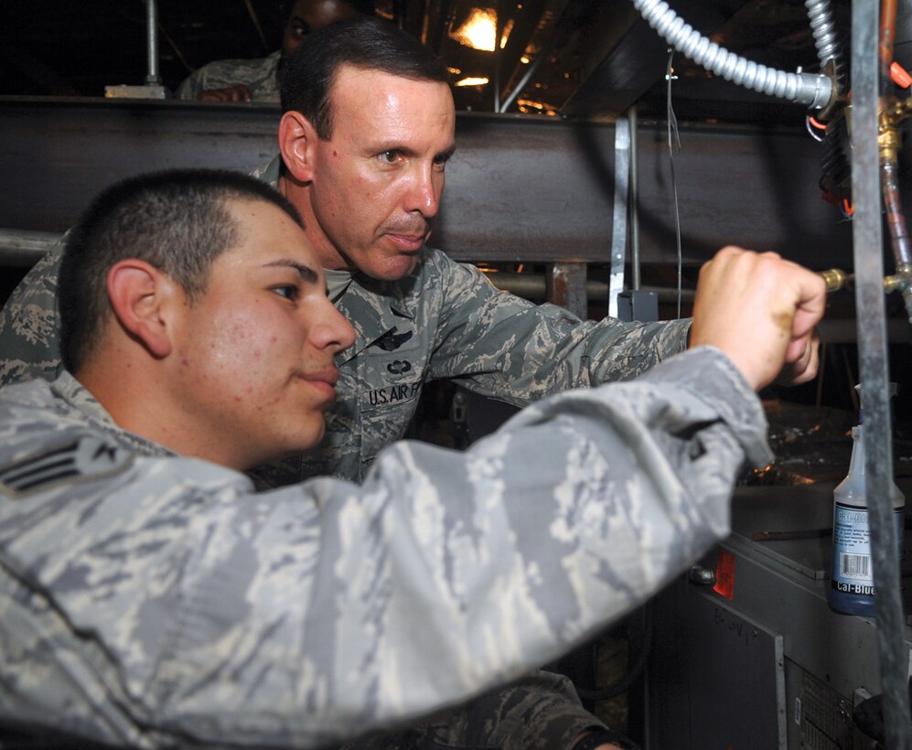 Senior Airman Frank Lainez, 316th Civil Engineer Squadron’s Heating, Ventilating, and Air Conditioning shop, shows Col. Steven M. Shepro, 316th Wing/Joint Base Andrews commander, how to check for holes in an air conditioning system on May 19. Colonel Shepro followed members of the HVAC shop as they fixed AC units on base as part of his last tactical level visit. (U.S. Air Force photo/ Senior Airman Melissa V. Brownstein)