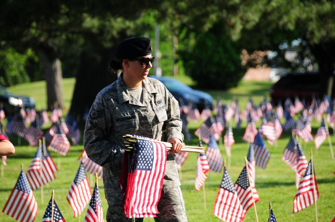 914th Security Forces Staff Sgt. Lynn Magistrale places an American flag on a grave during a Memorial Day ceremony May 31, 2010, Forest Lawn Cemetery Buffalo NY. During the morning thousands of flags where placed next to those men and woman who died while serving the United States military. (U.S. Air Force photo by Staff Sgt. Joseph McKee)